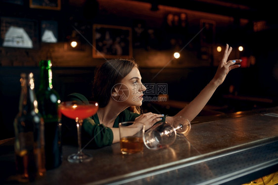 玻璃室内的奢华抑郁女人在酒吧柜台喝不同酒吧里一名女人类情感休闲活动夜生图片