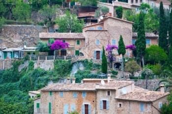 建筑物在西班牙巴利阿里群岛马洛卡MallorcaBalearicIslands有蜜蜂彩色干岩建筑配有绿窗百叶新鲜绿色抗争和紫布加图片