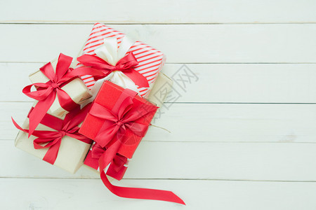红色的购物欢乐新年装饰品概念Flat提供了基本区别概念在家庭工作室办公桌上用木白色背景许多礼品盒标注了木白色背景的礼物箱冬天图片