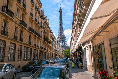 城市的蓝色法国巴黎阳光明媚的夏天巴黎阳光晴朗的日子在巴黎狭小街道埃菲尔铁塔上许多汽车停在离巴黎窄小街环视埃菲尔铁塔林荫大道图片