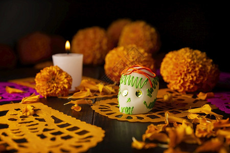 或者庆典花朵墨西哥纪念死者节的祭坛上通常使用的糖头盖骨蜡烛Cempasuchil花或Marigold和PapelPicado装饰图片
