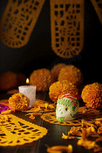 墨西哥纪念死者节的祭坛上通常使用的糖头盖骨蜡烛Cempasuchil花或Marigold和PapelPicado装饰盛开万寿菊背景图片
