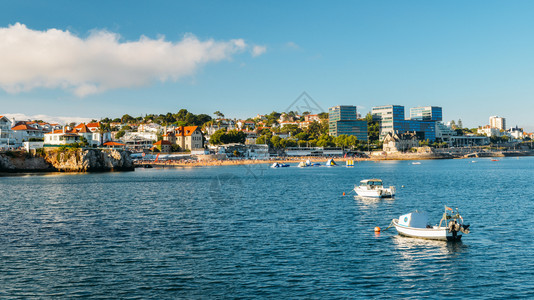 城市景观旅行夏季葡萄牙湾Cascais海滨城市风景期间葡萄牙湾有船只以及公共和拥挤的海滩夏季葡萄牙湾Cascais海边城市风景支图片