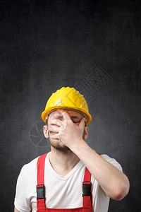 身戴黄色硬帽的建筑工人失望遮盖着他的脸部一位失望建筑工人的肖像压力消极总体图片