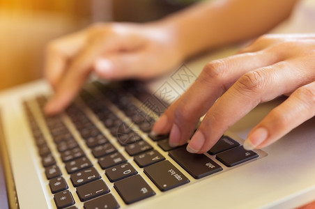博客按钮自由女佣手握在咖啡馆的键盘笔记本电脑上女孩使用笔记本打字网络搜索浏览软焦点图像坐着图片