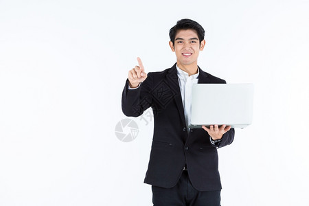 一个成功的企业拥有笔记本电脑手触摸用白色灰空间工作室背景所隔离的图像面板成功获得Asian青年商人的快乐指点空白控制板图片