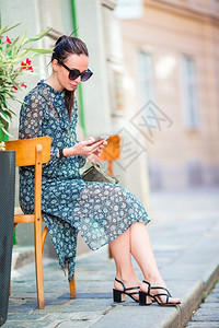 年轻的维也纳市外年轻有吸引力旅游者在意大利市外的年轻有吸引力旅游者在意大利城外的旅游者中由她的智能手机在城市里聊天风景观图片