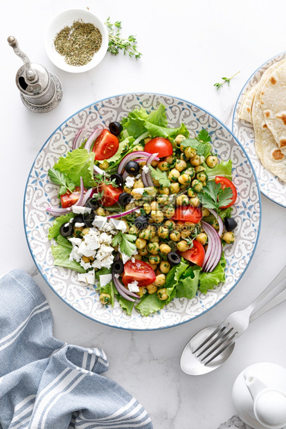 白色的莴苣地中海希腊沙拉和芝皮配有新鲜蔬菜和乳酪自然图片