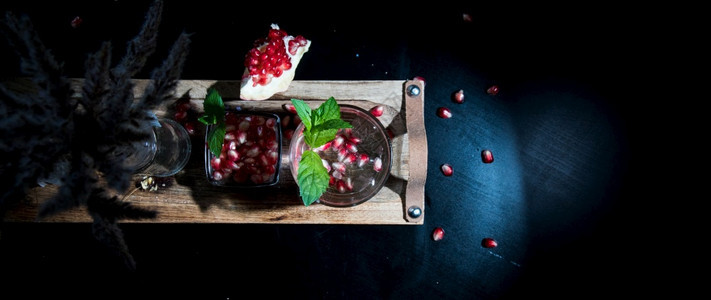 水果喝两杯多彩的夏季饮料在黑桌上加石榴和薄荷新鲜图片