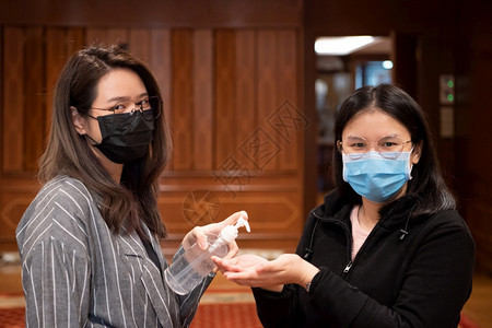 脸戴面罩和酒精抗菌剂的亚裔妇女戴上面具用防酒精抗乳胶凝呼吸道保护面具防止流行感bivid19或冠状corona害怕在概念疾病爆发图片