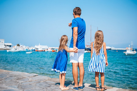 欧洲家庭度假父亲和孩子背景是希腊Mykonos镇的Mykonos镇在Mykonos岛户外玩乐的家庭建造基克拉泽斯岛屿图片