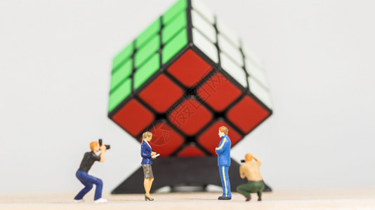 数学丰富多彩的娱乐男摄影师拍了魔方赢家3x的立方体在白色背景上的照片图片