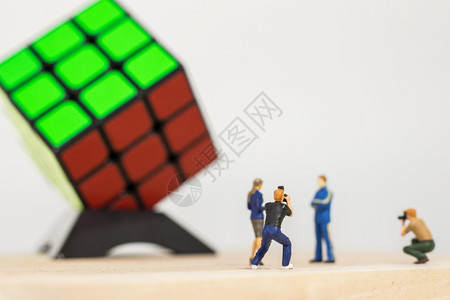 男摄影师拍了魔方赢家3x的立方体在白色背景上的照片社论逻辑正方形图片