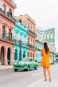 屋在旧哈瓦那流行街头的古巴旅游女客中在古巴哈瓦那流行地区的古巴旅游女客中古巴年轻女旅行者微笑童年镇图片