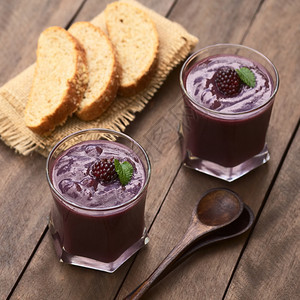 第一的木制厄瓜多尔传统浓密饮料叫ColadaMorada由煮紫玉米面粉和各种水果如草莓菠萝纳兰吉利亚葡萄巴哥黑莓等制作配有甘蔗糖图片