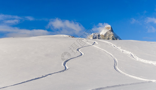 以山峰为背景的粉雪上自由骑行轨道以山峰为背景的粉雪上自由骑行轨道爬坡质地踪迹图片