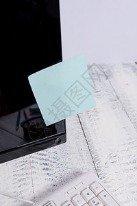 沟通工作场所互联网白色键盘标签纸贴在白色键盘上方的木制表Pc监视器上方面贴有蓝色笔记纸磁带的黑贴在白色键盘上方的黑计算机屏幕上图片