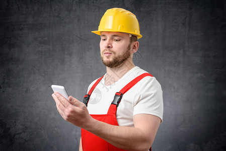 水管工人们年轻的建筑工人使用智能手机的肖像建筑工人使用智能手机的工序图片