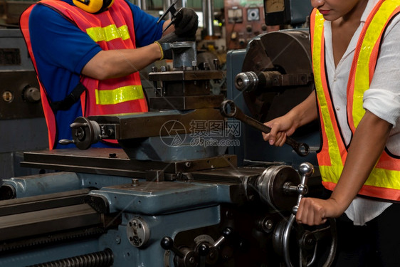 技术员在工厂车间使用机器设备的熟练工人组业和程员技术概念在工厂车间使用机器设备的熟练工人组拉丁程师图片