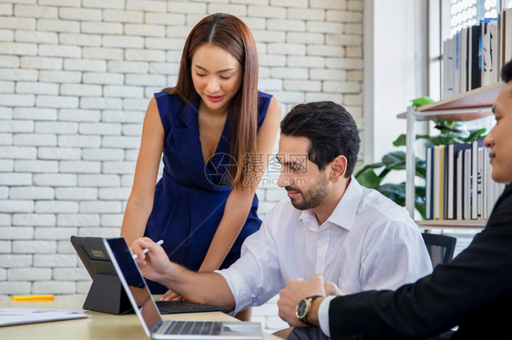 行政人员快乐的商业使用现代数字平板电脑而同事在办公室团队工作会议和伙伴关系概念的背景中进行互动的同业人员与务互动联合办公图片