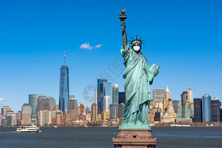 自由女神像戴外科面具当时Covid19在纽约克市风景河边联合州冠状流行建筑和上发生爆炸并带有旅游概念建筑学天空曼哈顿图片