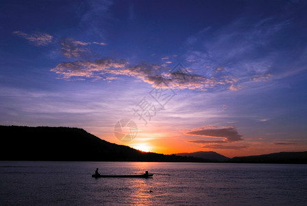 最佳休息日落时在湄公河田里捕鱼的男子天图片