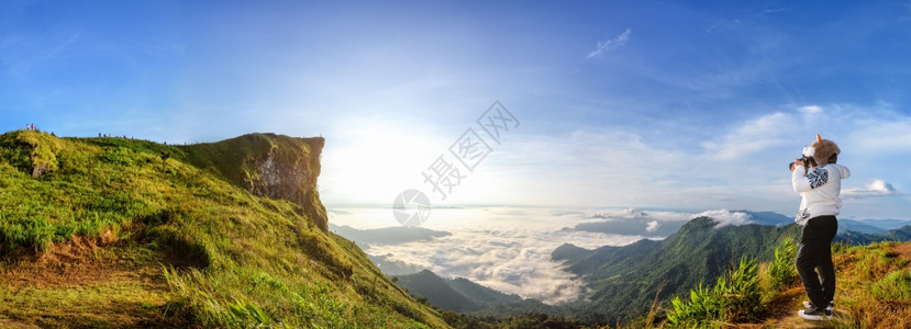 人们早晨天空泰国清莱省富奇发森林公园冬季山顶日出的全景美丽观自然太阳云雾明亮女游客正在拍照图片