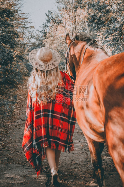 白种人天空穿着帽子的金马和发女孩在森林里散步时尚图片