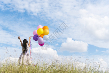 太阳户外快乐的可爱女孩拿着气球在绿色草地白云和蓝天空上运行快乐的天空手拿着充满活力的空气球在生日派对上玩欢乐的可爱女孩美丽图片