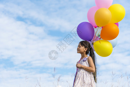 的天空手拿着充满活力的空气球在生日派对上玩欢乐的可爱女孩畅快背景