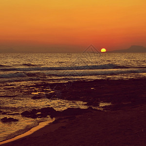 晚上美丽的夏天日落在海滩上惊人的景色与海浪和太阳反射背景假期和度旅行的背景希腊克里特岛金的热带图片