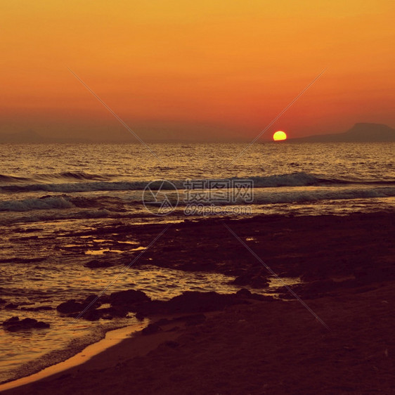 晚上美丽的夏天日落在海滩上惊人的景色与海浪和太阳反射背景假期和度旅行的背景希腊克里特岛金的热带图片