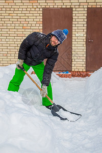 大雪后铲雪的男人图片