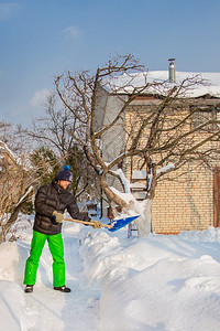 户外小路一个人清理他家附近的院子和雪花园一个阳光明媚的冬日天气晴朗一个男人清理他雪屋附近的院子一个阳光灿烂的冬季天晴图片