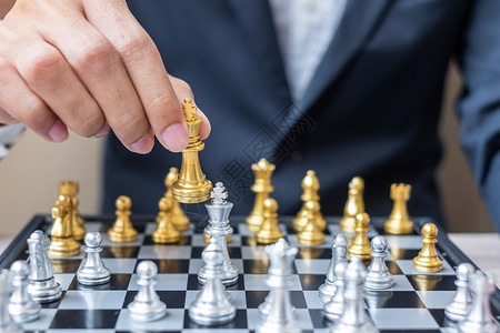 游戏男人在棋盘竞争战略成功管理商业规划中断和领导力概念期间商人用手搬运金牌象棋王人物和格斗士或对手的实战人数政治的图片