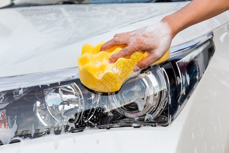 妇女手用黄色海绵洗头灯现代汽车或清洁洗概念女手用黄色海绵洗头污垢玻璃合金图片