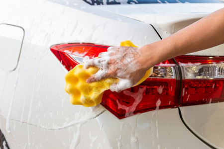 维护妇女手用黄色海绵清洗尾灯现代汽车或洗概念清洁器服务图片