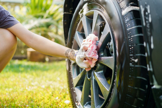 工人女手握洗车用微纤维布料对车辆进行消毒和防腐清洁对车辆进行清扫蜡泡沫图片
