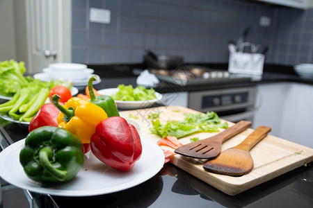 番茄一顿饭木勺烹调沙拉食品蔬菜盛放西红柿和胡萝卜盘子上的甜椒为幸福家庭烹饪食物享受生活方式厨房在家庭烹饪中食物厨房师健康人准备家图片
