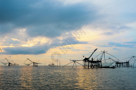 日出时宋卡湖美丽的自然景观和渔民正在使用竹子和网作为本地捕鱼工具在泰国帕塔龙班运河的克普拉捕鱼农村生活方式渔民在泰国日出农村生活图片