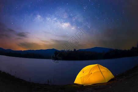 夜晚星空银河下的黄色帐篷图片