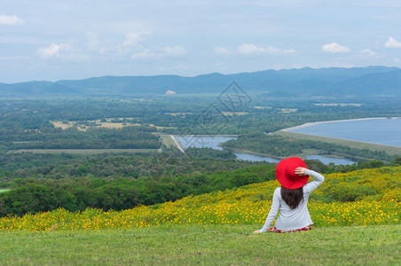 白种人女士身着自然花的美丽女子她穿着白色礼服和红帽子在泰国兰芒省MaeMohCoalMine的TungBuaTong墨西哥向日葵图片