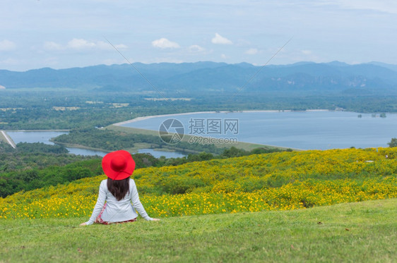 通东身着自然花的美丽女子她穿着白色礼服和红帽子在泰国兰芒省MaeMohCoalMine的TungBuaTong墨西哥向日葵田上穿图片