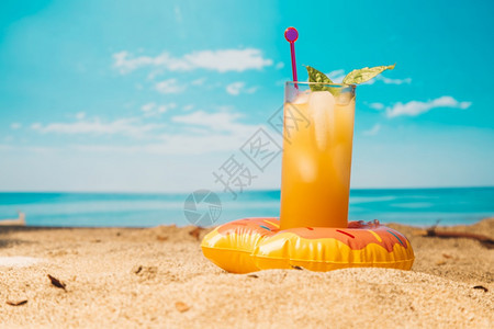 沙滩上的橙汁饮料图片