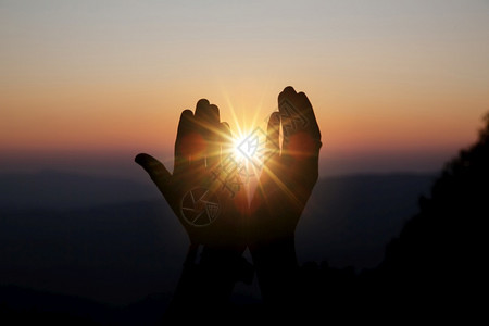 精神基督信仰的圣洁祷告将阳光照耀在模糊的美丽日落背景下光线超过图片