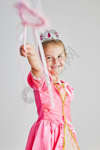 幸福小女孩享受公主的角色拿着魔杖头饰清楚喜悦图片