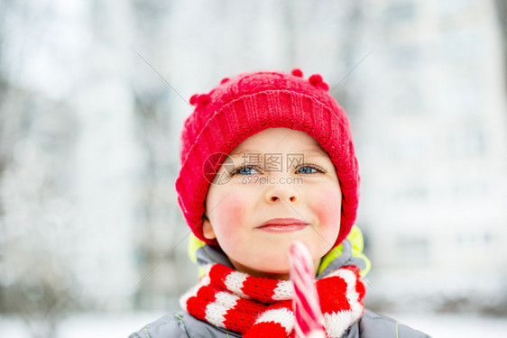 冬天街道上手拿圣诞棒糖的快乐男孩肖像子脸上的滑稽情绪冬天街道上手拿圣诞棒糖的快乐男孩肖像蜜糖来临运气图片