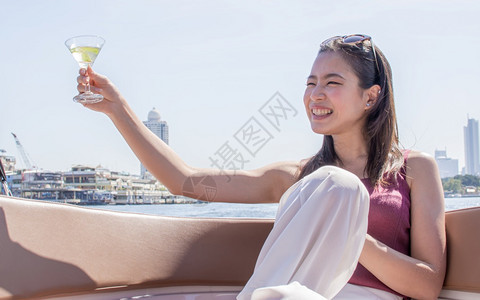 模型白色的坐着亚洲美丽女在旅行和坐船时喝着白葡萄酒和吐司身处美丽建筑风景与夏季旅行生活方式概念背景下在旅游和坐船上图片