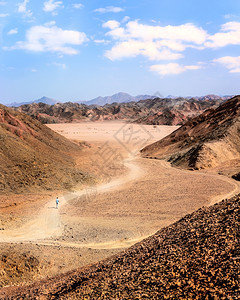 结石在埃及的头沙漠中有着许多颜色和人独自行走的山地上干燥步行图片