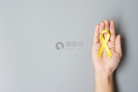 儿童癌症Sarcoma骨膀胱和预防意识月支持人们生活和患病儿童的金黄丝带以及世界癌症日概念保健及世界癌症日概念手二月童年图片